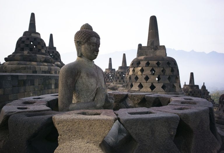 Buddha statue and stone stupas at Borobudur Temple in Central Java