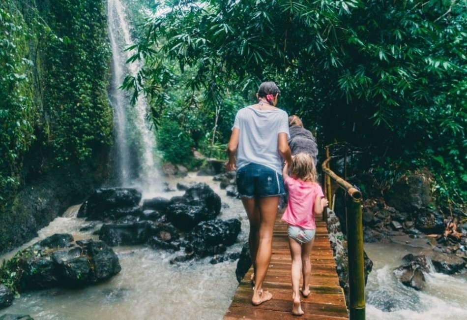 Family walking to a waterfall during a tailored nature tour in Indonesia