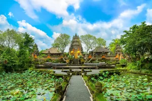 The ornate Pura Taman Saraswati temple in Ubud featuring a stone pathway through a lush lotus pond
