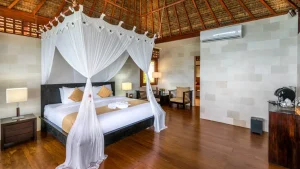 Elegant interior of a Wakatobi Dive Resort bungalow featuring high-end Balinese decor and a direct view of the ocean