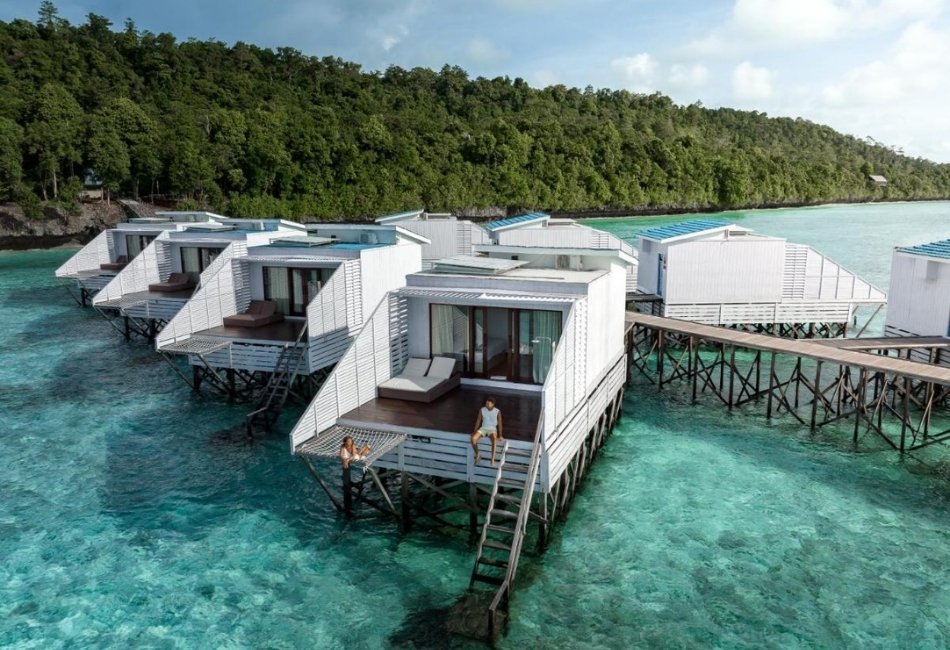 Overwater villas above clear turquoise water for a luxury island stay in Indonesia 