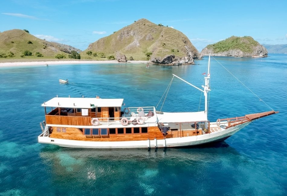 Private phinisi boat sailing through turquoise waters in Indonesia 