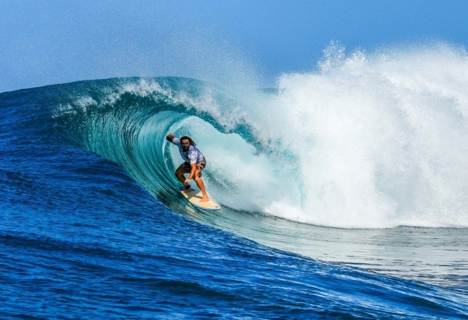 Surfer riding a large wave during a luxury adventure trip in Indonesia (1)