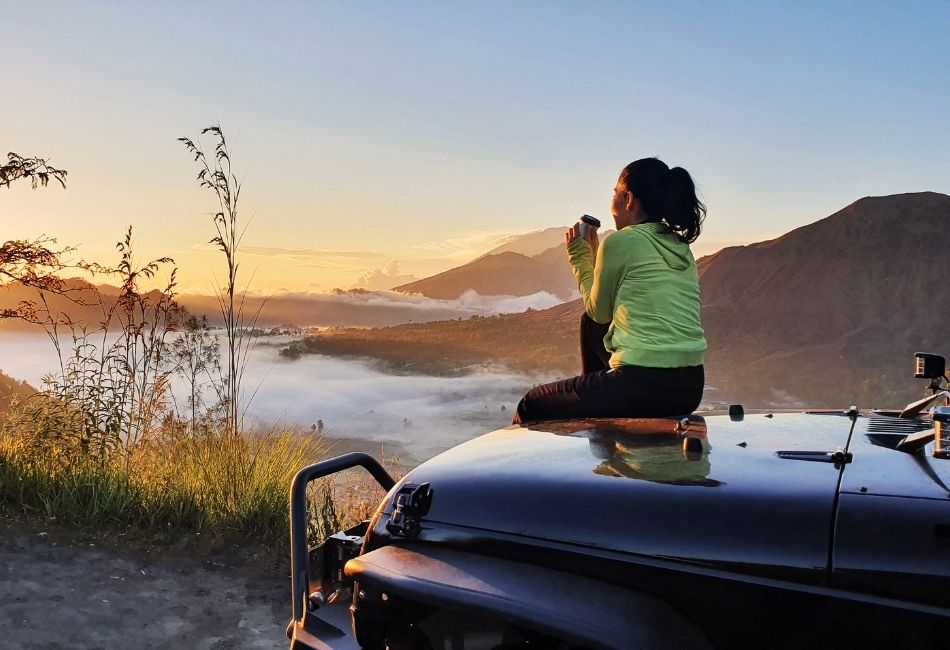 Woman Sitting on the 4WD Looking at Mount Batur
